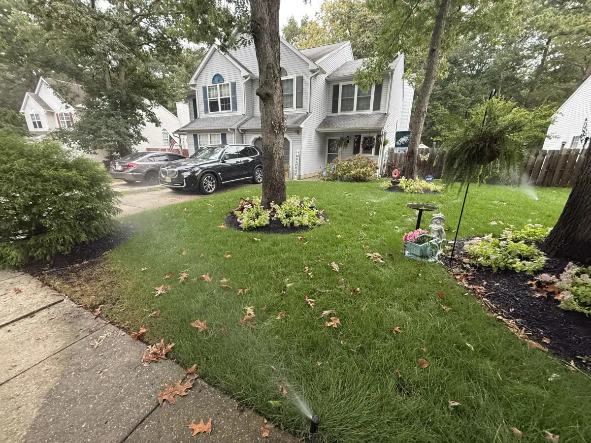 Lush green lawn with active sprinkler heads providing full coverage