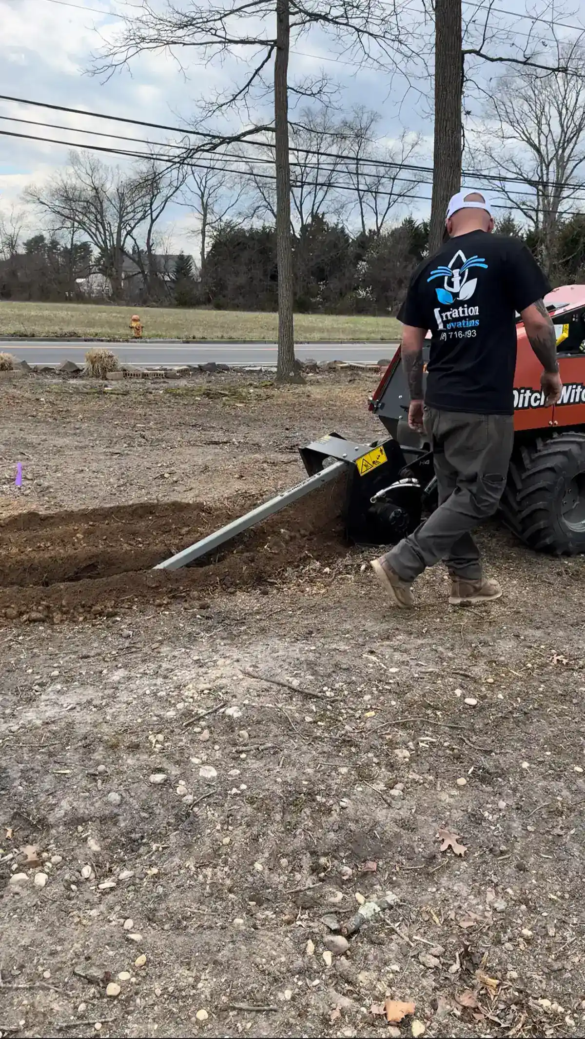 Irrigation Innovations crew operating a Ditch Witch trencher during a sprinkler system installation